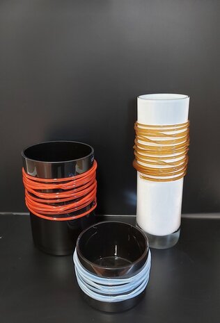 Windlicht van zwart glas omringt met rode glasstringers 